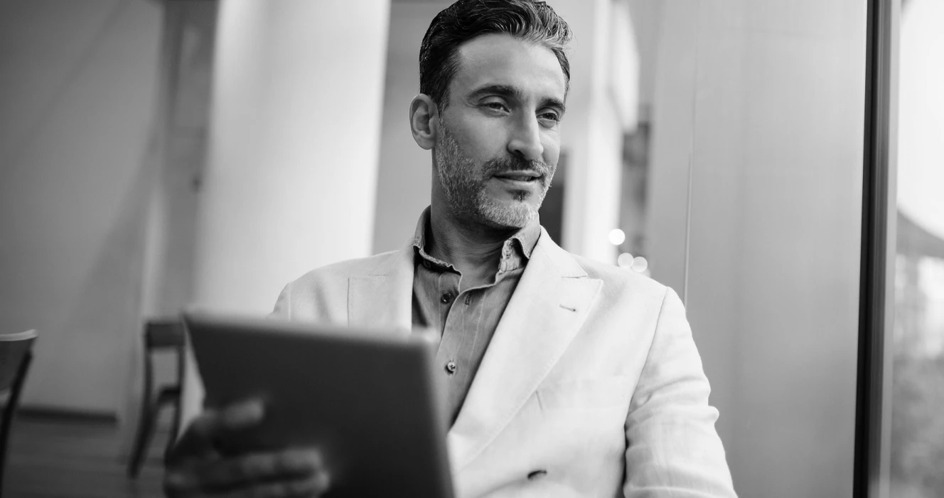 A man sitting in a meeting with his laptop