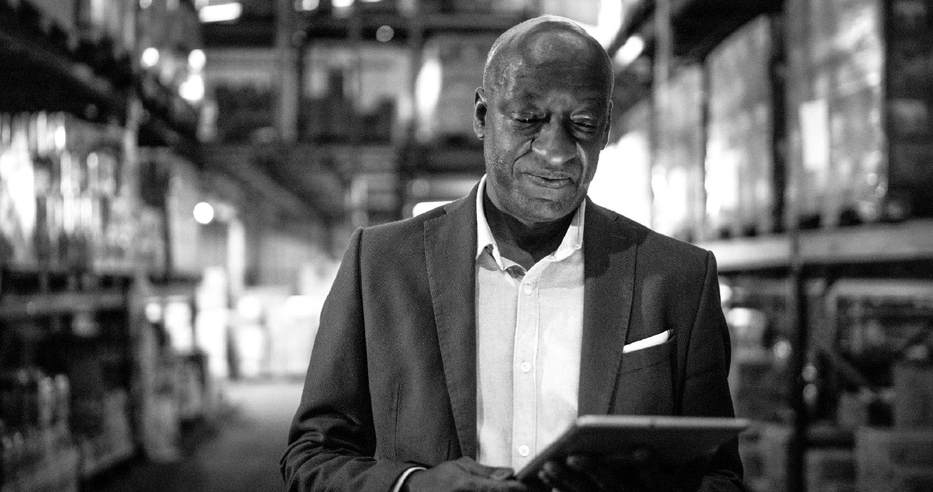 A man walking in a facility reviewing his financials