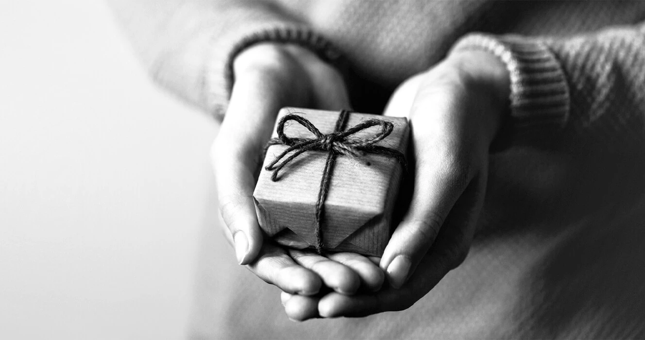 A person holding a small wrapped gift