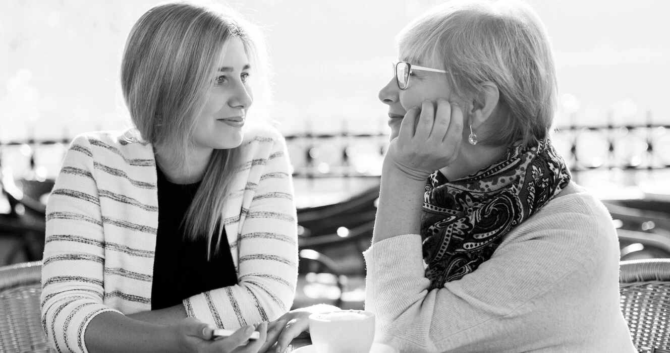 A mom and daugther having a conversaion at a cafe